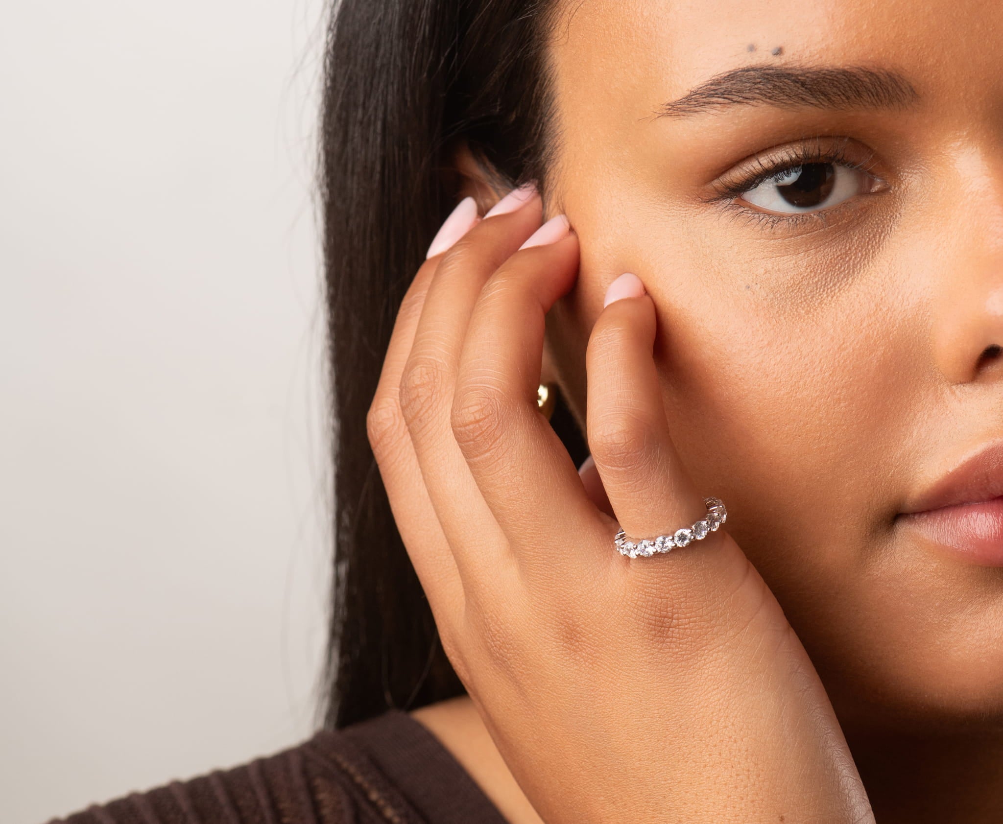 10K white gold eternity ring with round stones on finger