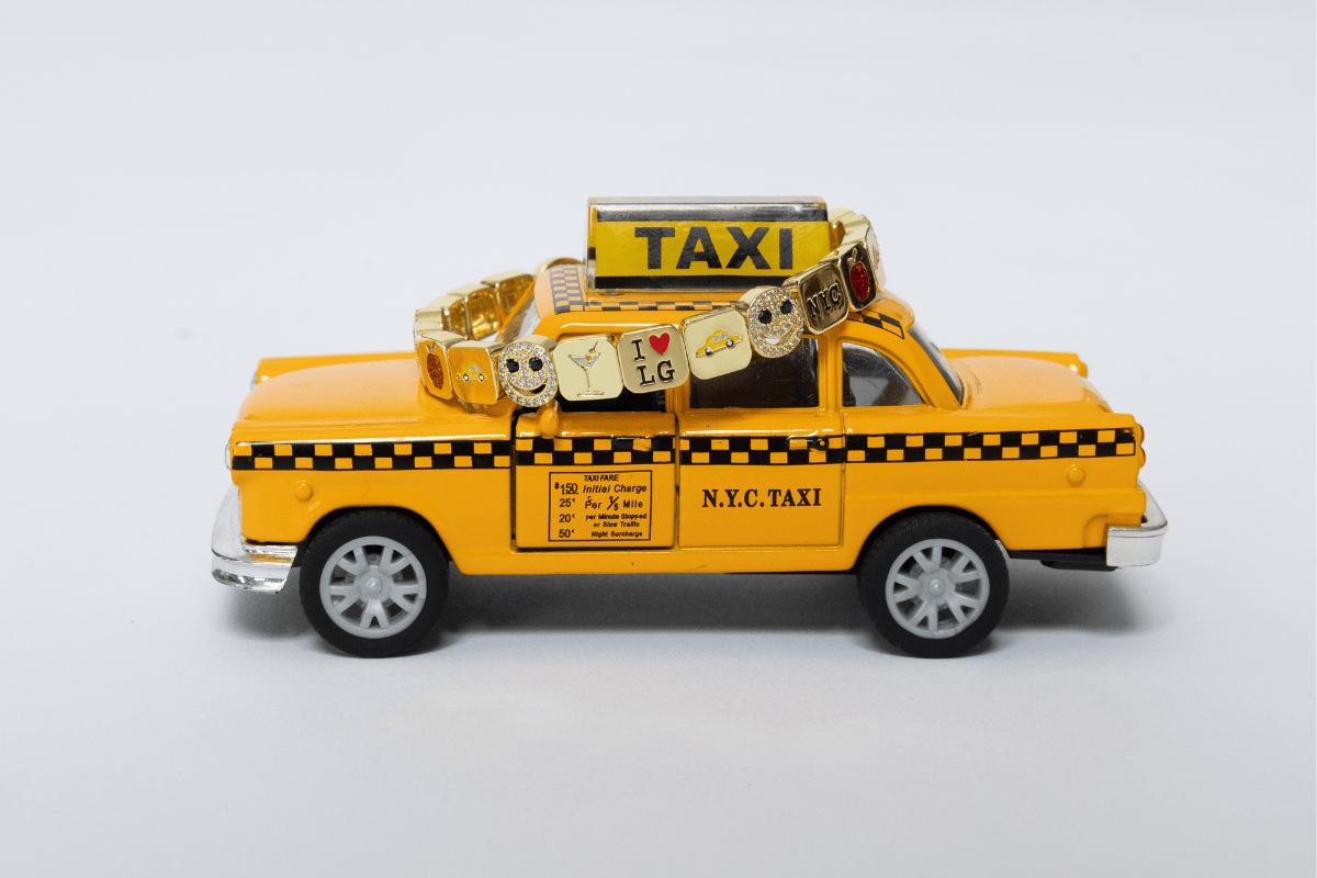Toy taxi with luggage on a light gray background