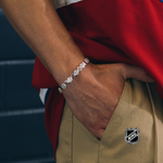 Silver-tone bracelet with round blue logo medallions on the wrist