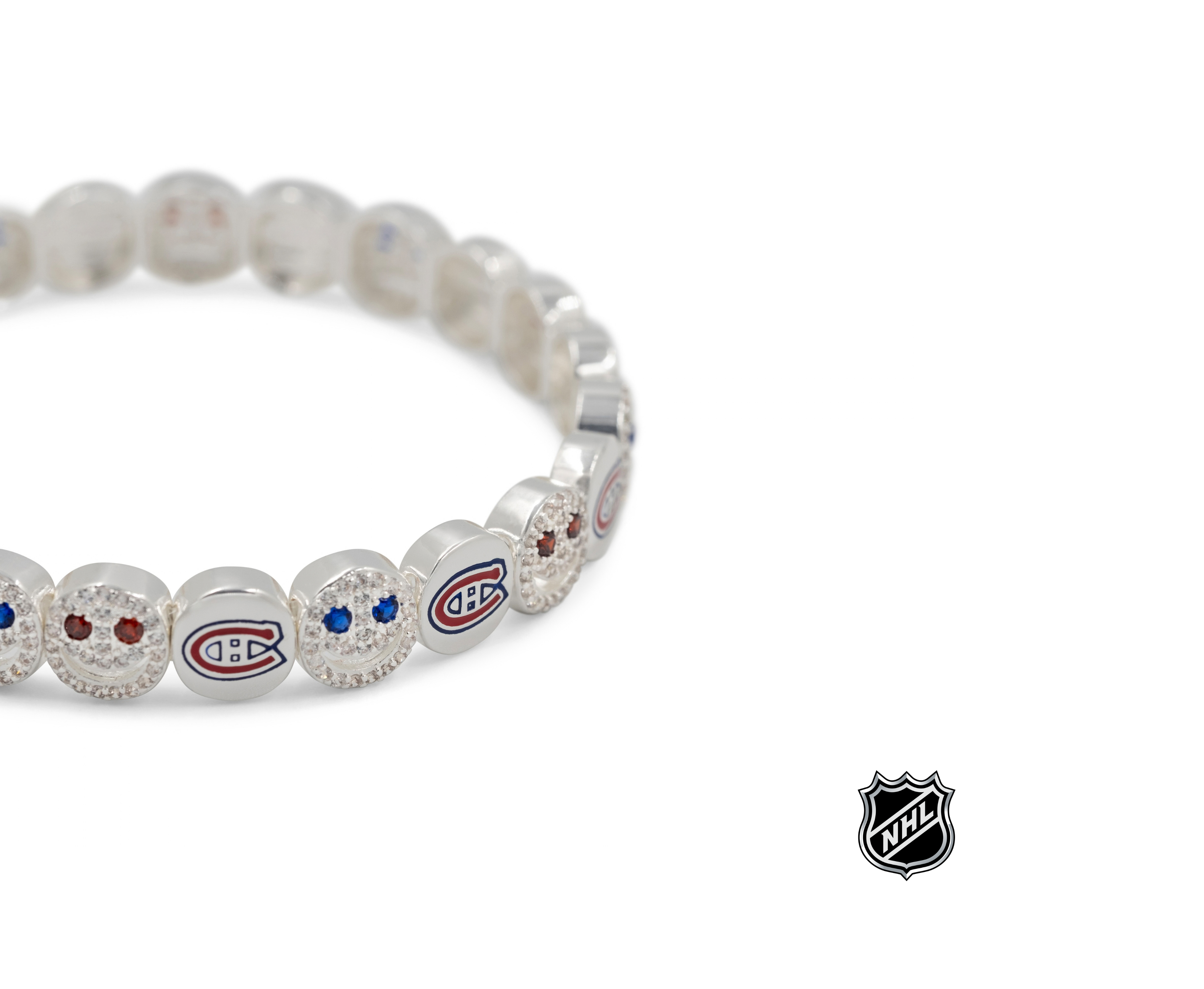 Close-up of white beaded bracelet with red and blue team logos and crystal detail.