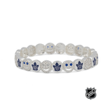 White beaded stretch bracelet with blue maple leaf emblems and crystal-like detail.
