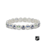 White beaded stretch bracelet with blue team logos and small green crystal-like accents.