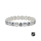 White beaded stretch bracelet with blue team logos and small green crystal-like accents.