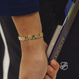Gold-tone NHL bracelet with circular logo charms along the wrist