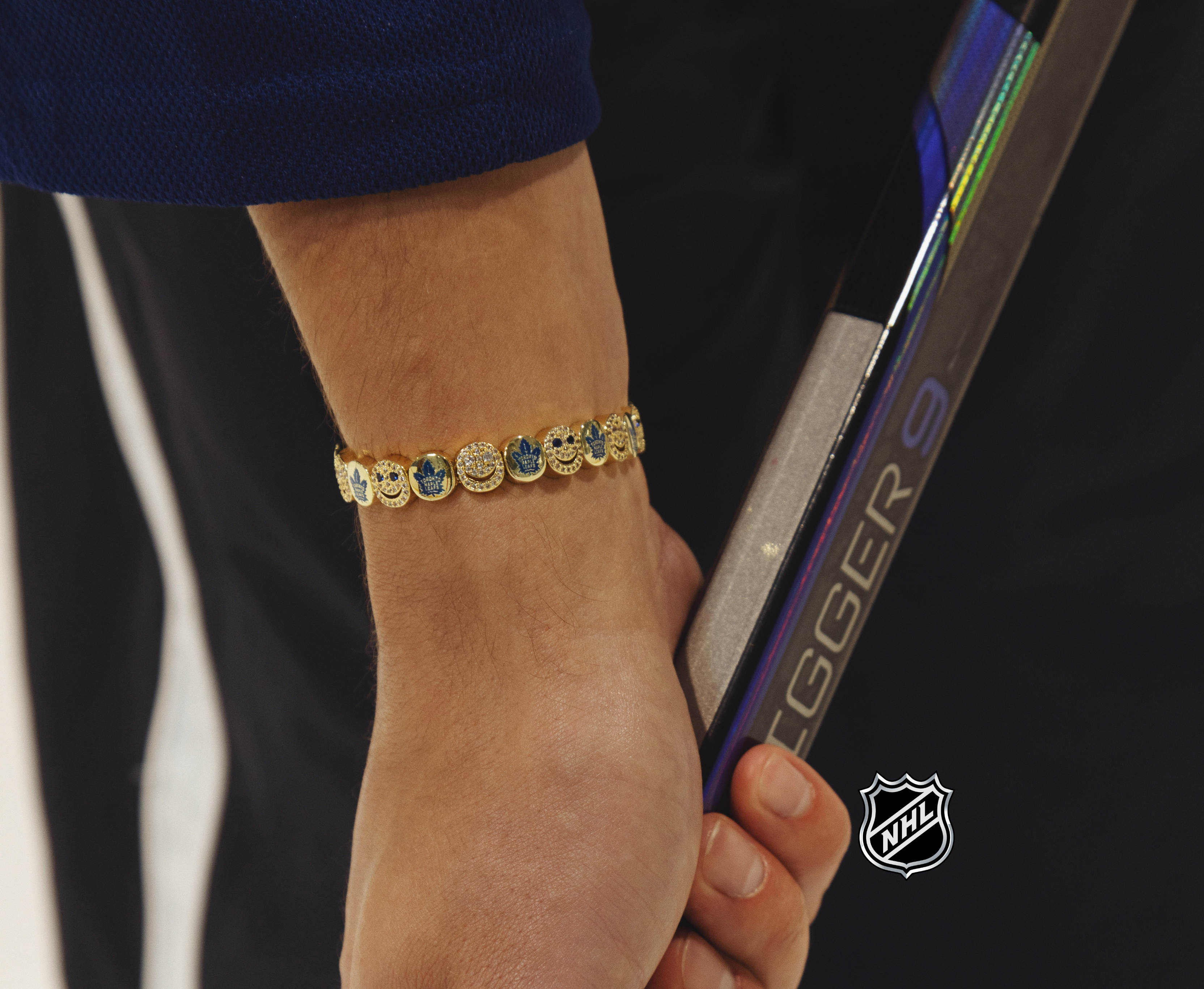 Gold-tone NHL bracelet with circular logo charms along the wrist