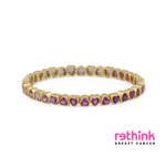 A yellow gold eternity bracelet featuring small heart-shaped purple gemstones set in a row, photographed on a clean white background.