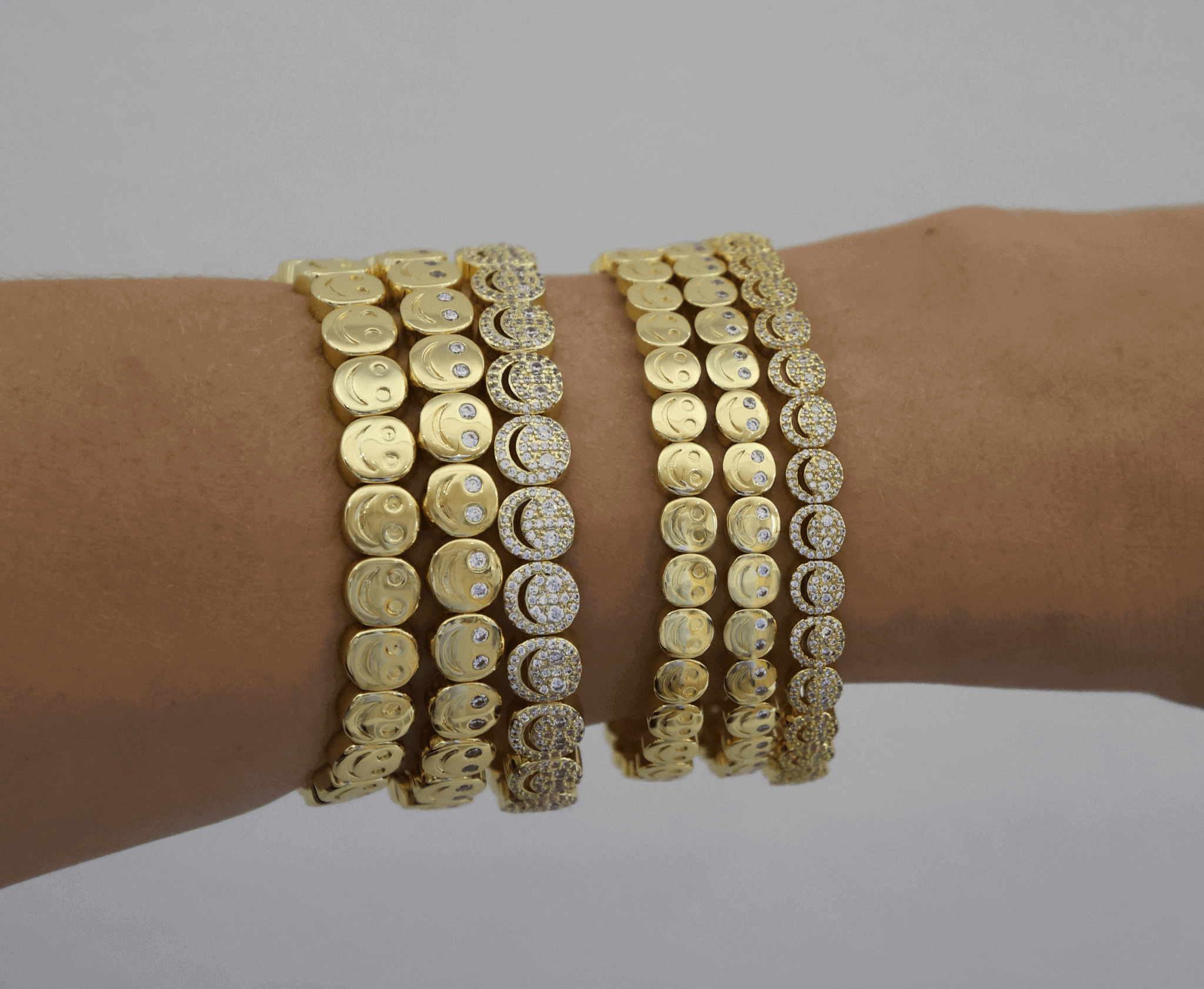 Gold and silver bracelet set on a wrist against a neutral background