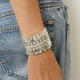 Silver bracelet on a wrist with denim background