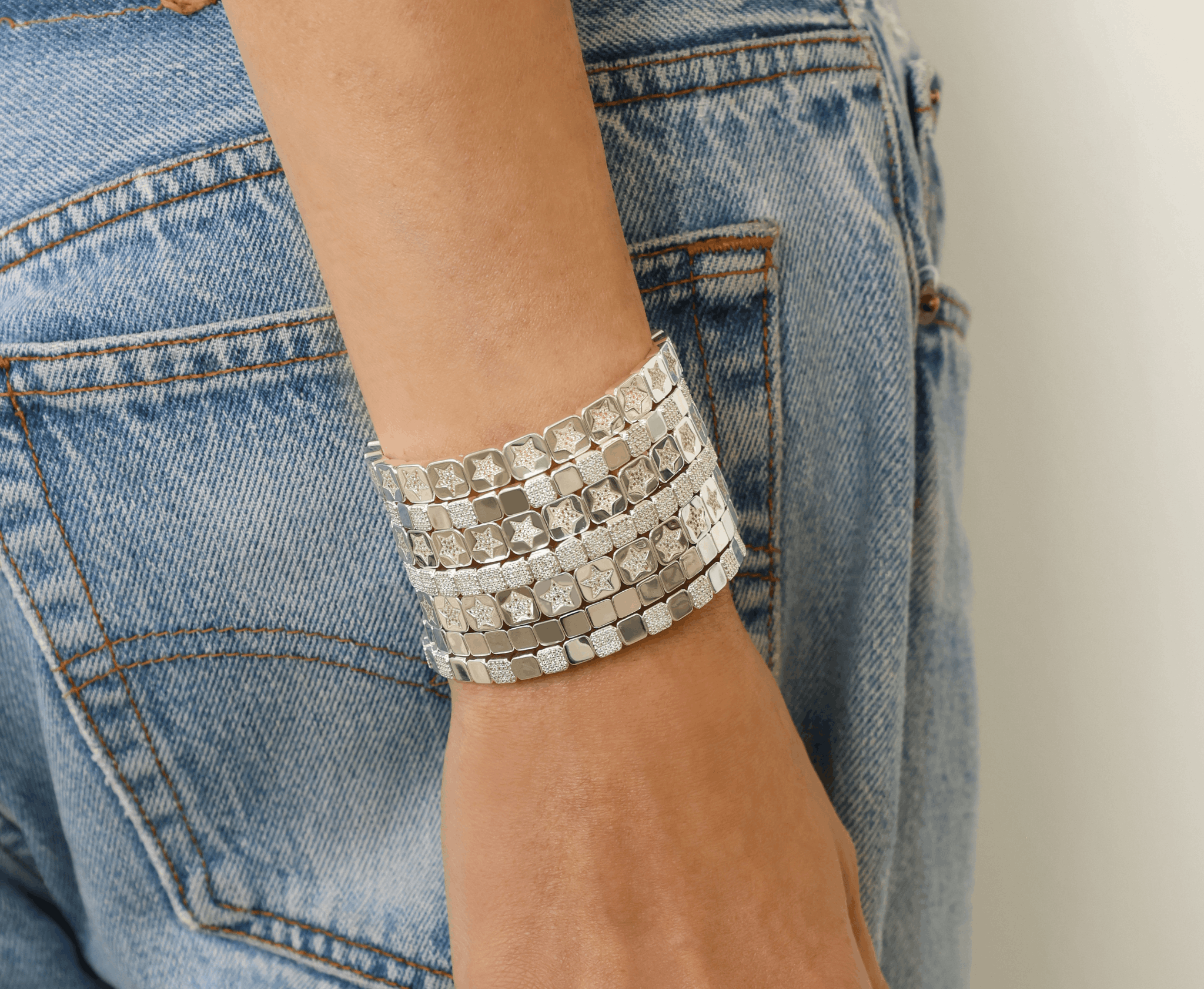 Silver bracelet on a wrist with denim background