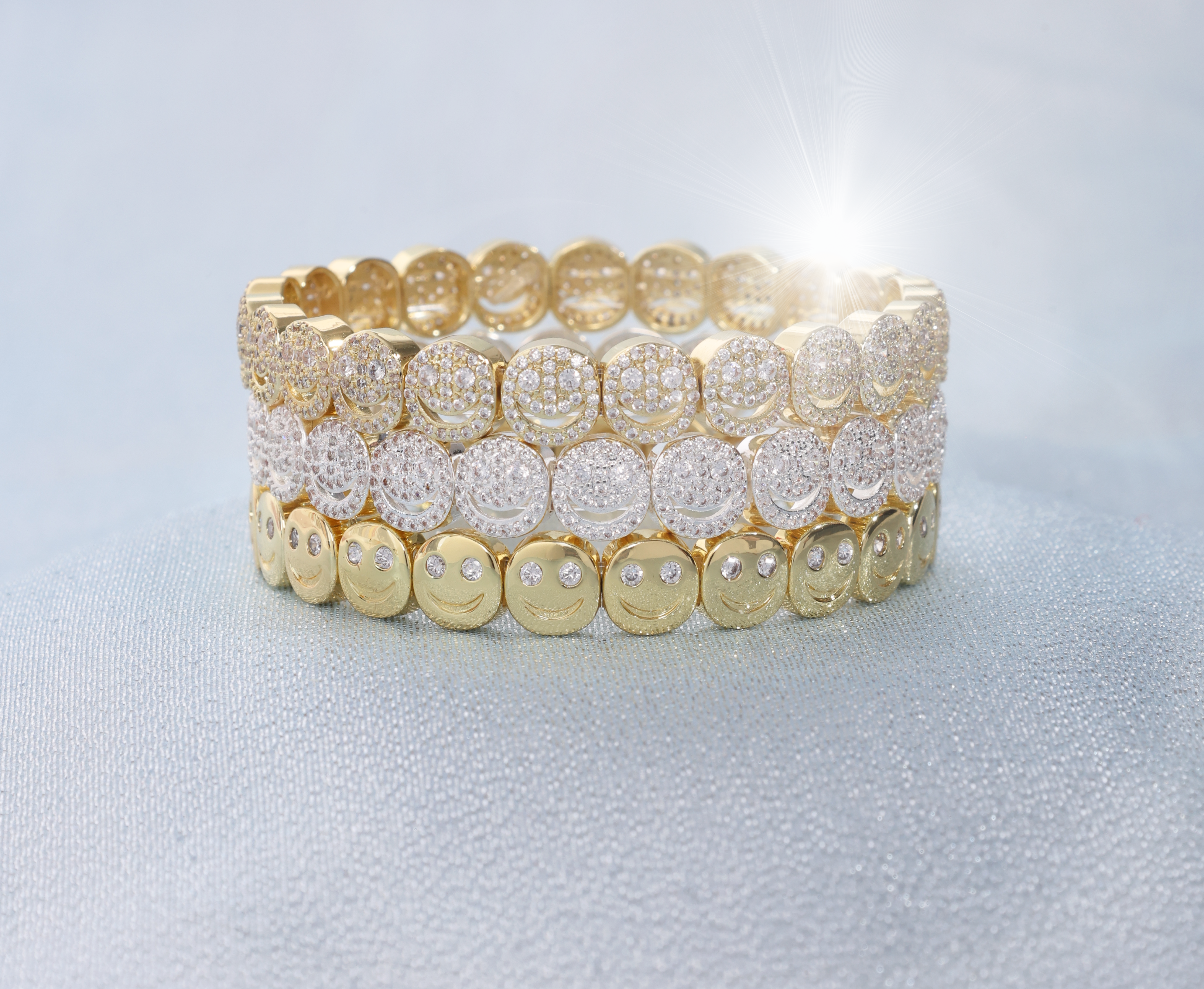 Set of gold and silver beaded bracelets on a light gray background