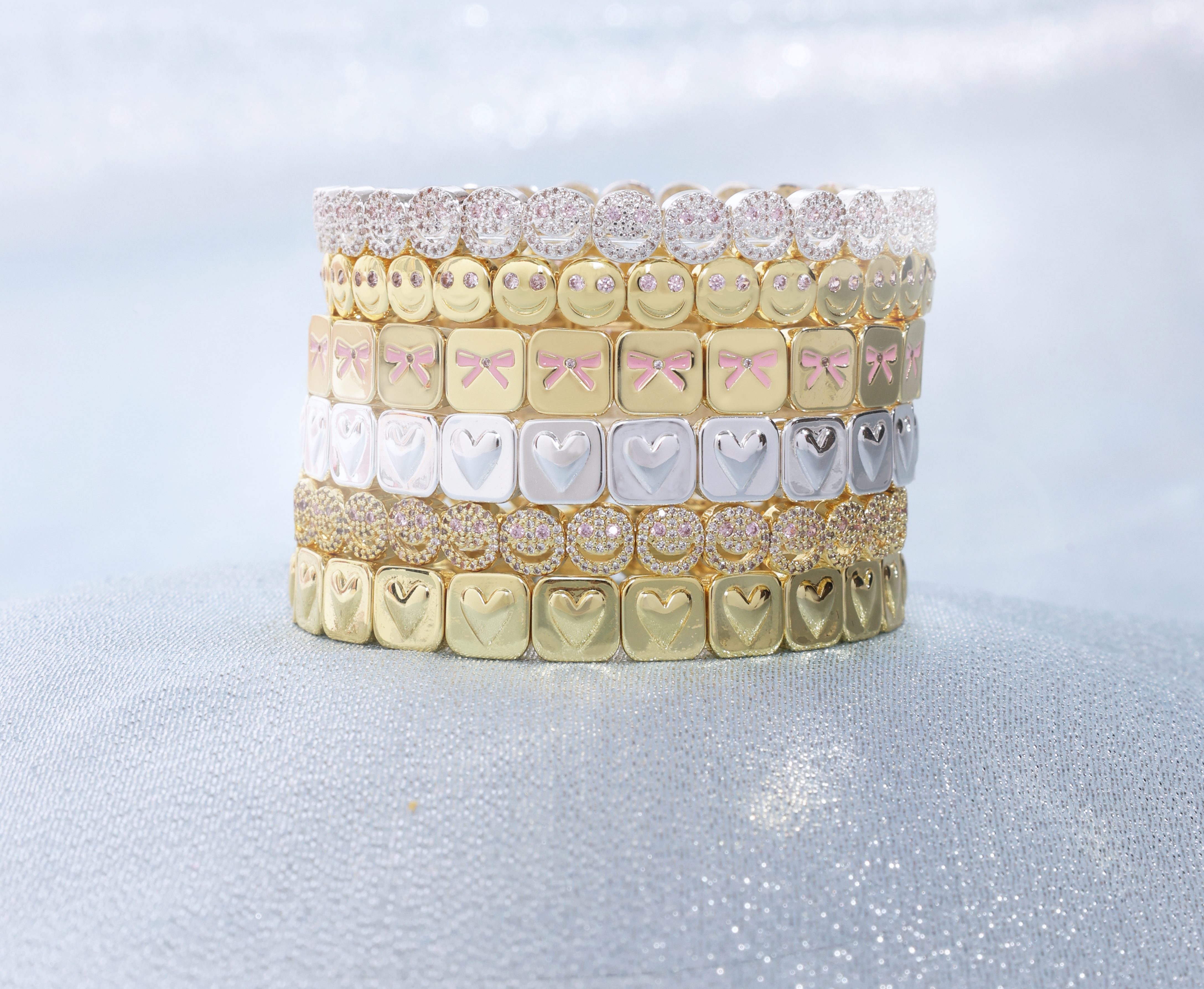 Stack of decorative dental retainers with various designs on a light gray background