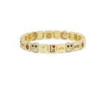Gold bracelet with various charms on a white background