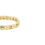 Gold bracelet with various charms on a white background