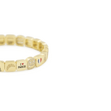 Gold beaded bracelet with various charms on a white background